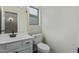 Bathroom featuring white cabinetry, quartz countertop, toilet, sink, and window at 25872 W Hilton Ave, Buckeye, AZ 85326