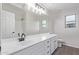 Bathroom features a white countertop with black fixtures, a mirror, and wood-look floors at 25872 W Hilton Ave, Buckeye, AZ 85326