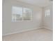 Bright bedroom with two windows, neutral carpet, and light-colored walls at 25872 W Hilton Ave, Buckeye, AZ 85326