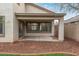 Covered patio with concrete flooring, surrounded by decorative rocks and partial view of backyard at 25872 W Hilton Ave, Buckeye, AZ 85326