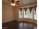 Bedroom with hardwood floors and curtains, complemented by a ceiling fan and natural lighting at 2830 W Grenadine Rd, Phoenix, AZ 85041