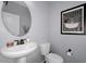 Stylish powder room featuring a sleek pedestal sink, and a vintage-inspired art print at 3541 E Amber Ln, Gilbert, AZ 85296