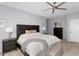 Neutral Primary bedroom featuring a dark wood bed frame, ceiling fan and plush carpeting at 3541 E Amber Ln, Gilbert, AZ 85296