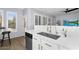 Detailed view of kitchen with stainless sink, modern faucet, and white cabinets with brass hardware at 3541 E Amber Ln, Gilbert, AZ 85296