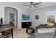 Living room featuring a gray sectional, ceiling fan, flat screen television and desk at 3541 E Amber Ln, Gilbert, AZ 85296