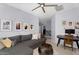 Living room featuring a gray sectional, ceiling fan, desk and Gathering photos at 3541 E Amber Ln, Gilbert, AZ 85296