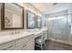 Modern bathroom with double vanity, a makeup vanity and frameless glass shower at 36518 N Crucillo Dr, Queen Creek, AZ 85140