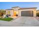 Attractive home exterior featuring a two-car garage, desert landscaping, and a well-lit entrance at 36518 N Crucillo Dr, Queen Creek, AZ 85140