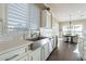 Bright, white kitchen featuring stainless sink, light countertops, and shuttered windows overlooking yard at 36518 N Crucillo Dr, Queen Creek, AZ 85140