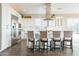 Elegant white kitchen featuring stainless steel appliances, a center island with seating, and ample natural light at 36518 N Crucillo Dr, Queen Creek, AZ 85140