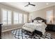 Comfortable main bedroom boasts neutral tones, plantation shutters, patterned rug, and ceiling fan at 36518 N Crucillo Dr, Queen Creek, AZ 85140