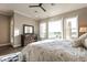 Bright main bedroom with windows offering golf course views, ceiling fan, and dark wood furnishings at 36518 N Crucillo Dr, Queen Creek, AZ 85140