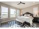 Comfortable main bedroom boasts neutral tones, plantation shutters, patterned rug, and golf course view at 36518 N Crucillo Dr, Queen Creek, AZ 85140