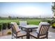 Outdoor dining area with table and chairs, surrounded by lush greenery and offering stunning views of the golf course at 36518 N Crucillo Dr, Queen Creek, AZ 85140