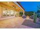 Beautiful outdoor patio with travertine tile, fire pit, and outdoor seating area at 36518 N Crucillo Dr, Queen Creek, AZ 85140