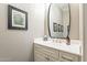 Elegant powder room with a decorative mirror, stylish fixtures, and a neutral color scheme at 36518 N Crucillo Dr, Queen Creek, AZ 85140