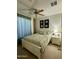 Cozy bedroom featuring a white bed frame, soft floral bedding, and natural light at 36610 W Picasso St, Maricopa, AZ 85138