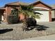 Charming single-story home featuring a well-maintained yard with desert landscaping and a palm tree at 36610 W Picasso St, Maricopa, AZ 85138