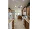 Bright kitchen area featuring tile floors, wood cabinets, white appliances, and views into adjacent rooms at 36610 W Picasso St, Maricopa, AZ 85138