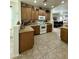 Kitchen area featuring tile floors, wood cabinets, and views into an adjacent room at 36610 W Picasso St, Maricopa, AZ 85138