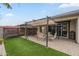 Backyard featuring a pergola, patio seating, artificial turf and sliding door leading to the house at 38101 W Santa Maria St, Maricopa, AZ 85138