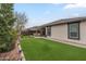 Spacious backyard featuring a covered patio, artificial turf, walkway, well-maintained landscaping and seating area at 38101 W Santa Maria St, Maricopa, AZ 85138