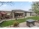 Well-maintained backyard featuring a covered patio, artificial turf, brick pavers, seating area and a fire pit at 38101 W Santa Maria St, Maricopa, AZ 85138