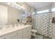 Modern bathroom featuring a double sink vanity with tiled floors, industrial shelving, and decorative shower curtain at 38101 W Santa Maria St, Maricopa, AZ 85138