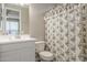 Bright bathroom featuring a white single sink vanity and a floral pattern shower curtain at 38101 W Santa Maria St, Maricopa, AZ 85138