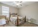 Relaxing bedroom with a metal framed bed, classic armchair, ceiling fan, and natural light from the window at 38101 W Santa Maria St, Maricopa, AZ 85138