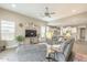 Cozy living room with plush grey sofas, wood-look tile flooring, and an open layout to the kitchen at 38101 W Santa Maria St, Maricopa, AZ 85138