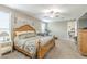 Spacious main bedroom with wood accents, ceiling fan, sitting area with couch and access to the bathroom at 38101 W Santa Maria St, Maricopa, AZ 85138