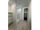 This bathroom features a tiled walk-in shower, built in storage shelving, and access to a walk-in closet at 38150 W Bello Ln, Maricopa, AZ 85138