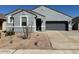 Charming single-story home features a gray exterior, low maintenance landscaping, and an attached two-car garage at 38150 W Bello Ln, Maricopa, AZ 85138