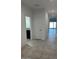 Bright hallway featuring neutral tile flooring, white walls, and access to various rooms in the home at 38150 W Bello Ln, Maricopa, AZ 85138