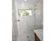 Modern walk-in shower with marble tile and gold fixtures at 4002 E Rockwood Dr, Phoenix, AZ 85050