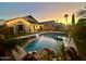 Inviting backyard pool with rock features and a view of the home at sunset at 4210 E Rosemonte Dr, Phoenix, AZ 85050