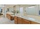 Bathroom featuring a dual vanity, a glass block wall, a soaking tub, and views of the main bedroom at 42123 N Long Cove Way, Anthem, AZ 85086