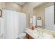 Bright bathroom showcasing a white shower curtain, vanity with sink, mirror, and decorative accents at 42123 N Long Cove Way, Anthem, AZ 85086