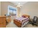 Cozy bedroom with natural light, a ceiling fan, and an inviting bed with a patterned quilt at 42123 N Long Cove Way, Anthem, AZ 85086