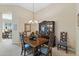 Formal dining area featuring a wood table, decorative chairs, and a glass-front display cabinet at 42123 N Long Cove Way, Anthem, AZ 85086