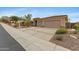 Attractive home exterior featuring a wide driveway, desert landscaping, and a three-car garage at 42123 N Long Cove Way, Anthem, AZ 85086