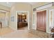 Inviting home foyer with decorative rug, paneled wood door, and adjacent office space at 42123 N Long Cove Way, Anthem, AZ 85086