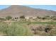 Houses on a golf course with desert landscaping and mountains in the background on a bright, clear day at 42123 N Long Cove Way, Anthem, AZ 85086