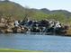 Beautiful waterfall feature on a golf course pond with desert mountains in the background under a bright sky at 42123 N Long Cove Way, Anthem, AZ 85086