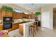 Well-lit kitchen featuring wooden cabinetry, a breakfast bar, and modern appliances at 42123 N Long Cove Way, Anthem, AZ 85086