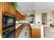 Stylish kitchen with wooden cabinets, quartz countertops, and a breakfast bar at 42123 N Long Cove Way, Anthem, AZ 85086