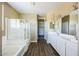 Bright bathroom with a glass shower, soaking tub, and dual sink vanity at 42256 W Lucera Ln, Maricopa, AZ 85138