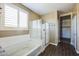 Modern bathroom features a soaking tub, glass shower and neutral color palette at 42256 W Lucera Ln, Maricopa, AZ 85138