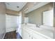 Bathroom featuring a double sink vanity, large mirror, and shower-tub combo with wood-look floors at 42256 W Lucera Ln, Maricopa, AZ 85138